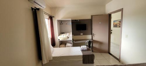 a small room with a bed and a mirror at Hotel Goedert in Major Vieira