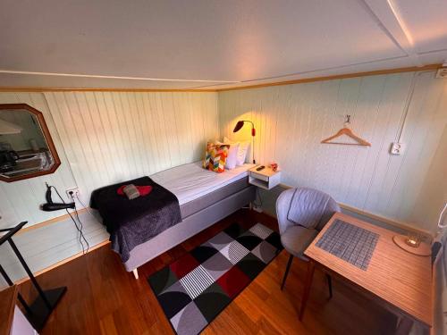 a small bedroom with a bed and a chair at Daltorps skola, Övernattningsstuga H, Self check in, Übernachtungskabine H in Skövde