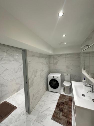 a bathroom with a toilet and a washing machine at Nōema Residences II in Nafpaktos