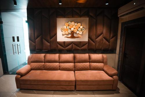 a brown couch in a room with a painting on the wall at KAR Towers in Ārani
