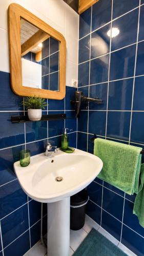 a bathroom with a white sink and blue tiles at L'école buissonnière chambres et table d'hôtes in La Celle-Dunoise