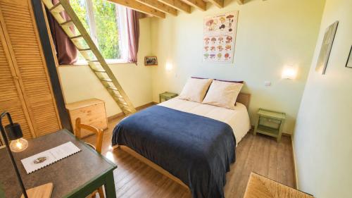 a small bedroom with a bed with a blue blanket at L'école buissonnière chambres et table d'hôtes in La Celle-Dunoise