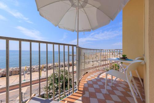 a balcony with a table and an umbrella and the ocean at HOMESTWENTY3 - Home seven - Renovated in 2026 in Caorle