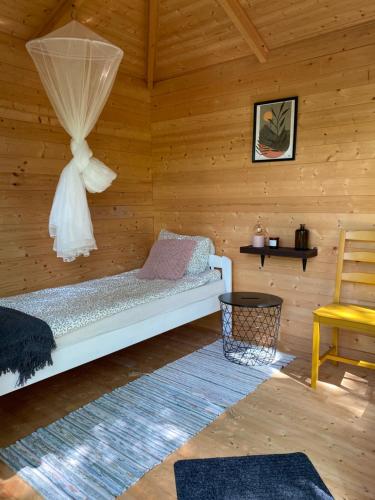 a room with a bed in a wooden cabin at Pendu talu kämping in Orissaare