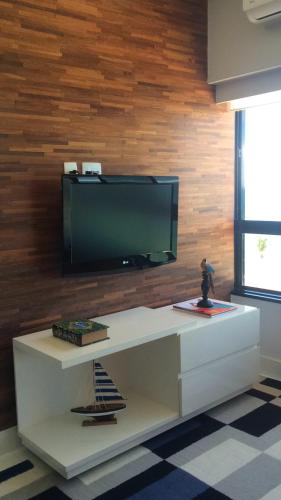 uma sala de estar com uma televisão na parede em Lindo Apto em Ondina com Vista em Salvador