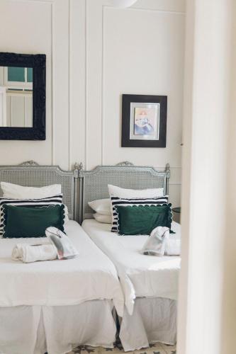 two beds with green and white pillows in a room at Casa Kilig 40 in Santa Cruz de Tenerife