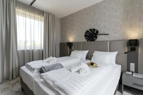 a large white bed with a teddy bear sitting on it at Szauter Aparthomes A in Győr