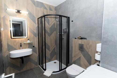 a bathroom with a shower and a toilet and a sink at Szauter Aparthomes A in Győr