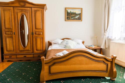 a bedroom with a wooden bed and a dresser at Rezydencja Jagiellońska in Sanok