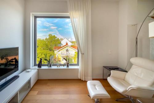 a living room with a large window and a white chair at Panorama Suite in Hanko in Hanko