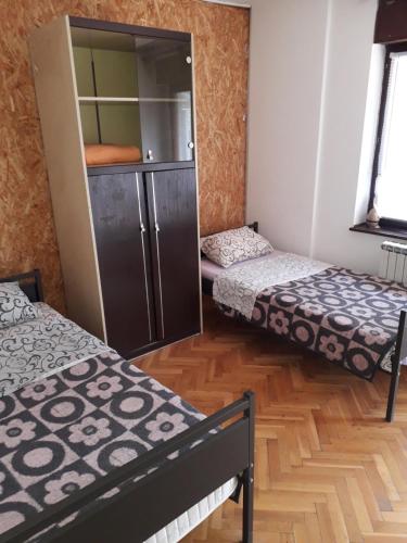 a room with two beds and a cabinet in it at Petrovic in Sombor