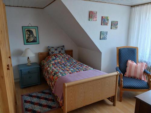 a bedroom with a bed and a chair at Ferienwohnung Lenhardt in Barkenholm