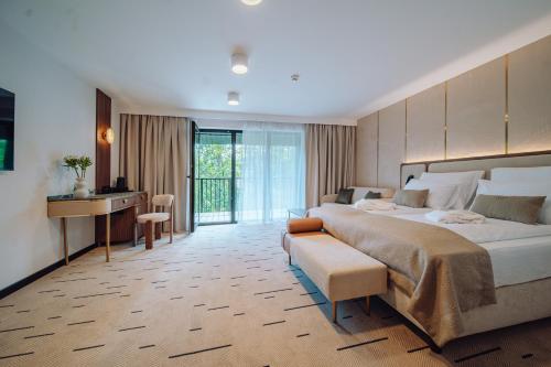 a hotel room with a large bed and a desk at Mariental Hotel & SPA in Szklarska Poręba
