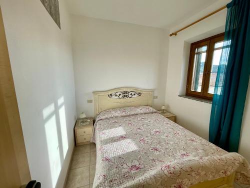 a bedroom with a bed in a room with a window at Rosmarino Apartment in Seccheto