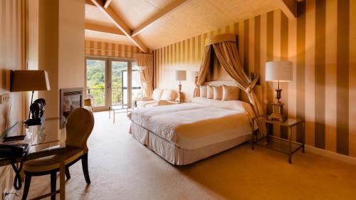 a bedroom with a king sized bed and a desk and a desk at Restaurant Hotel Merlet in Schoorl
