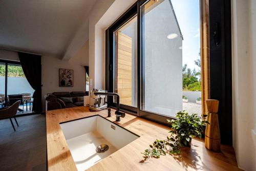 a kitchen with a sink and a large window at Villa Plitvina in Vela Luka