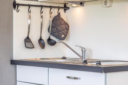 a kitchen with a sink and utensils on the wall at 50112 Ferienwohnung "Coco" in Carolinensiel