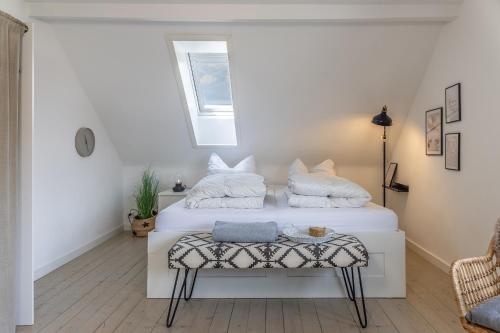 a bedroom with a white bed with a window at 50112 Ferienwohnung "Coco" in Carolinensiel