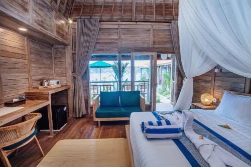 a bedroom with a bed and a desk and a chair at The Old Island Huts in Nusa Lembongan