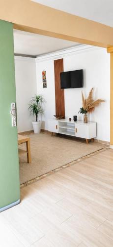 a living room with a flat screen tv on a wall at Petit villa centre harhoura Près de la plage in Temara