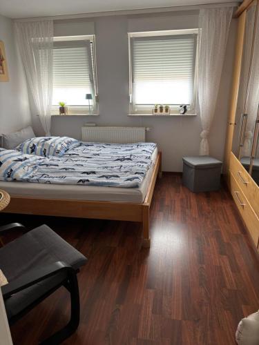 a bedroom with a bed and two windows at Ferienwohnung Hocke in Wulfsen