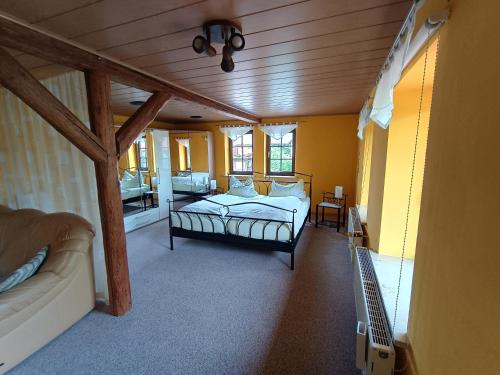a bedroom with a bed and a couch in a room at Hainich-Ferienwohnung in Hörselberg-Hainich