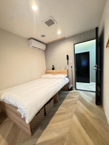 a bedroom with a large bed and a large window at Guest house雅 in Matsudo