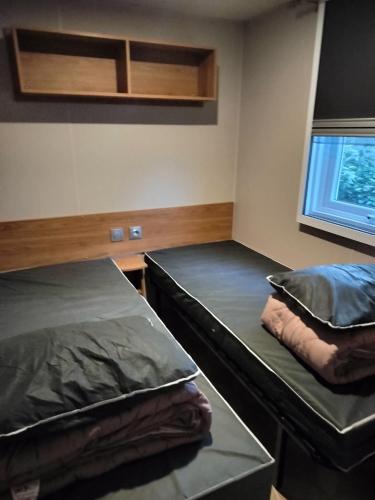 a room with two beds and a window at Bienvenue chez Diamina et Patrick in La Tremblade