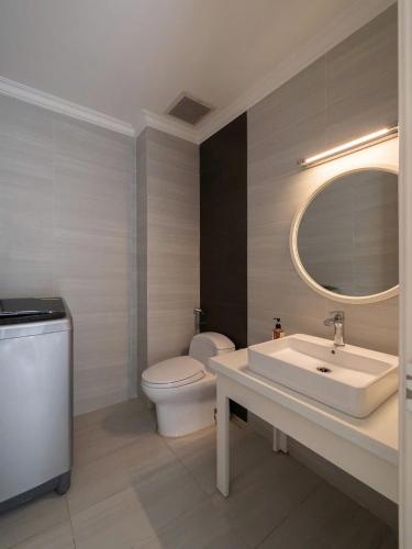 a bathroom with a sink and a toilet and a mirror at Aquar Grand Park in Gò Công