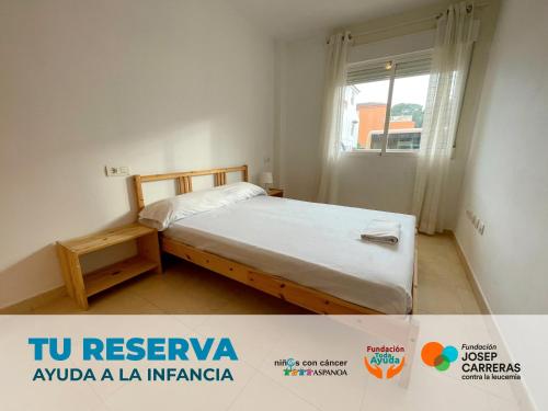 a small bedroom with a bed and a window at Apartamentos Los Almendros 3000 in Oropesa del Mar