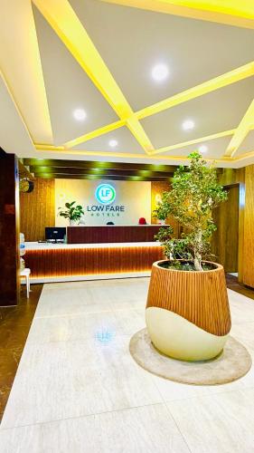 a lobby with a large pot with a tree in it at FarGo Hotels By Lowfare Hotels in Bangalore