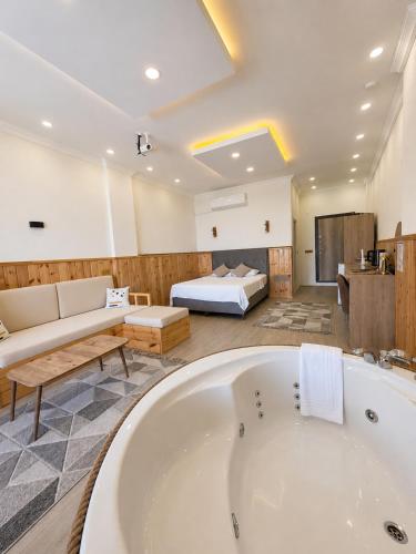 a large bathroom with a tub and a bed at Aurora Suit Bungalov in Rize