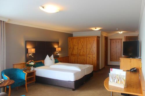 a hotel room with a bed and a television at Hotel Landhaus Feckl in Böblingen