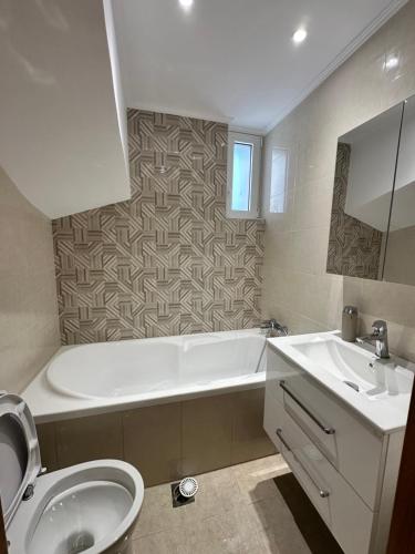 a bathroom with a tub and a toilet and a sink at Nōema Residences I in Nafpaktos