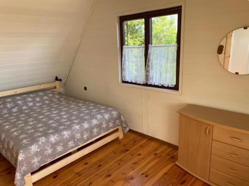 a small bedroom with a bed and a window at Domek letniskowy Fuleda in Fuleda