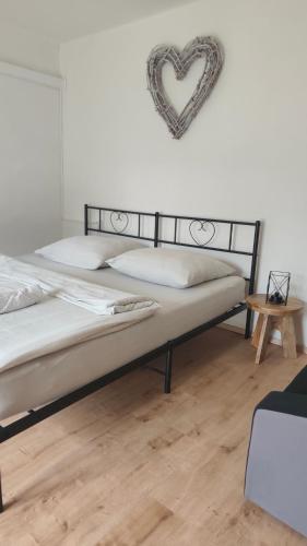 a bedroom with a bed with a heart on the wall at Chalupa ve Svinné in Svinná