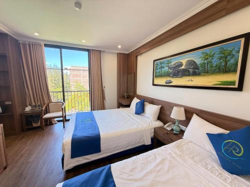a hotel room with two beds and a large window at Khách sạn Hercury FLC Sầm Sơn in Sầm Sơn