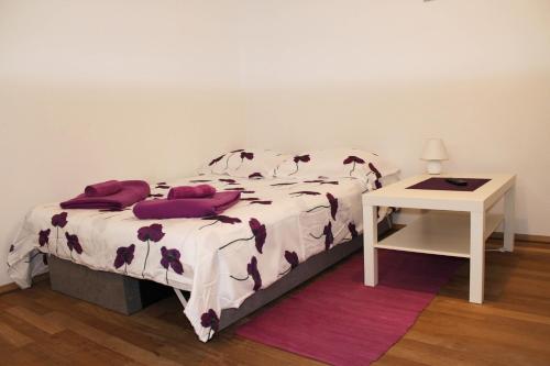 a bedroom with a bed with purple pillows and a table at Apartman Renata in Biograd na Moru