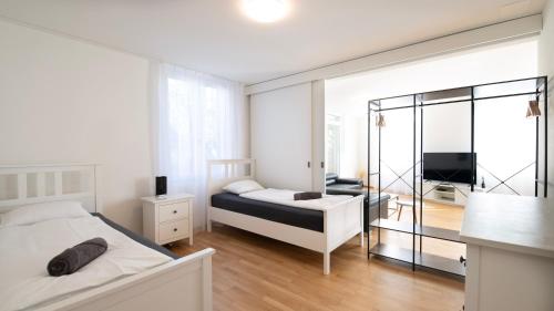 a bedroom with a bed and a television in it at Swiss Suites Oberglatt in Oberglatt