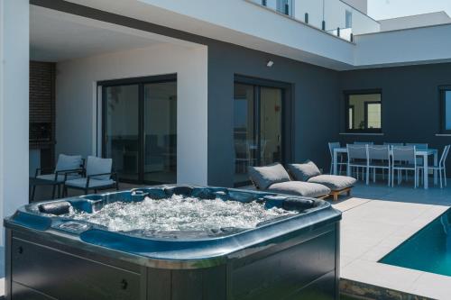 a large jacuzzi tub in a living room at Villa Locki with jacuzzi, private pool and sea view in Lourinhã