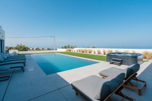 a pool with chaise lounge chairs next to a swimming pool at Villa Locki with jacuzzi, private pool and sea view in Lourinhã
