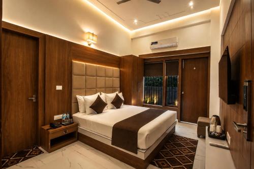 a bedroom with a large bed and a television at Signature StayZ - Amar Singh Palace Near Taj Mahal in Agra