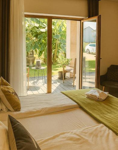 a bedroom with a bed and a sliding glass door at Bali Butique Rooms in Nyergesújfalu
