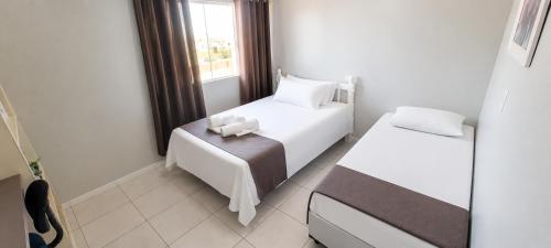 a small bedroom with two beds and a window at Hotel Goedert in Major Vieira