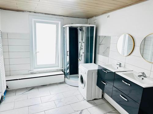 a bathroom with a washing machine and a washer and dryer at Echappée Rétro in Frameries