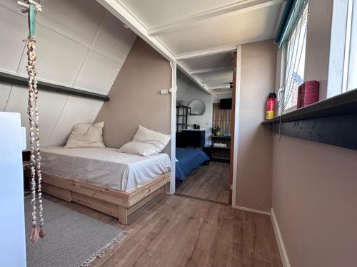 a small bedroom with a bed in a room at Barefoot Cottage in Noordwijk