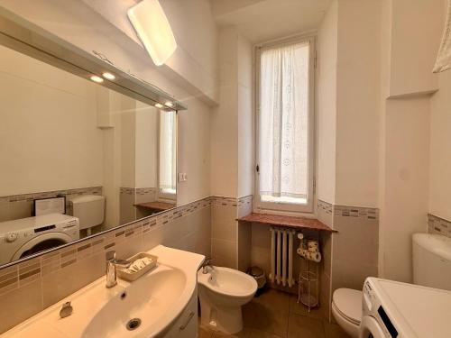 a bathroom with a sink and a toilet and a mirror at La Gardenia del ducato in Parma