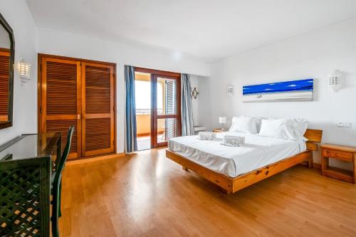 a bedroom with a bed with white sheets and wooden floors at Bellavista Avenida By BeGuest in Albufeira