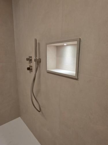 a shower in a bathroom with a mirror at EMERALD Suites Cervia in Cervia