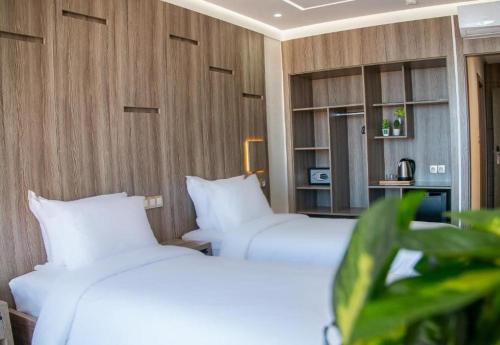 two beds with white pillows in a room at Marchica Hotel in Nador